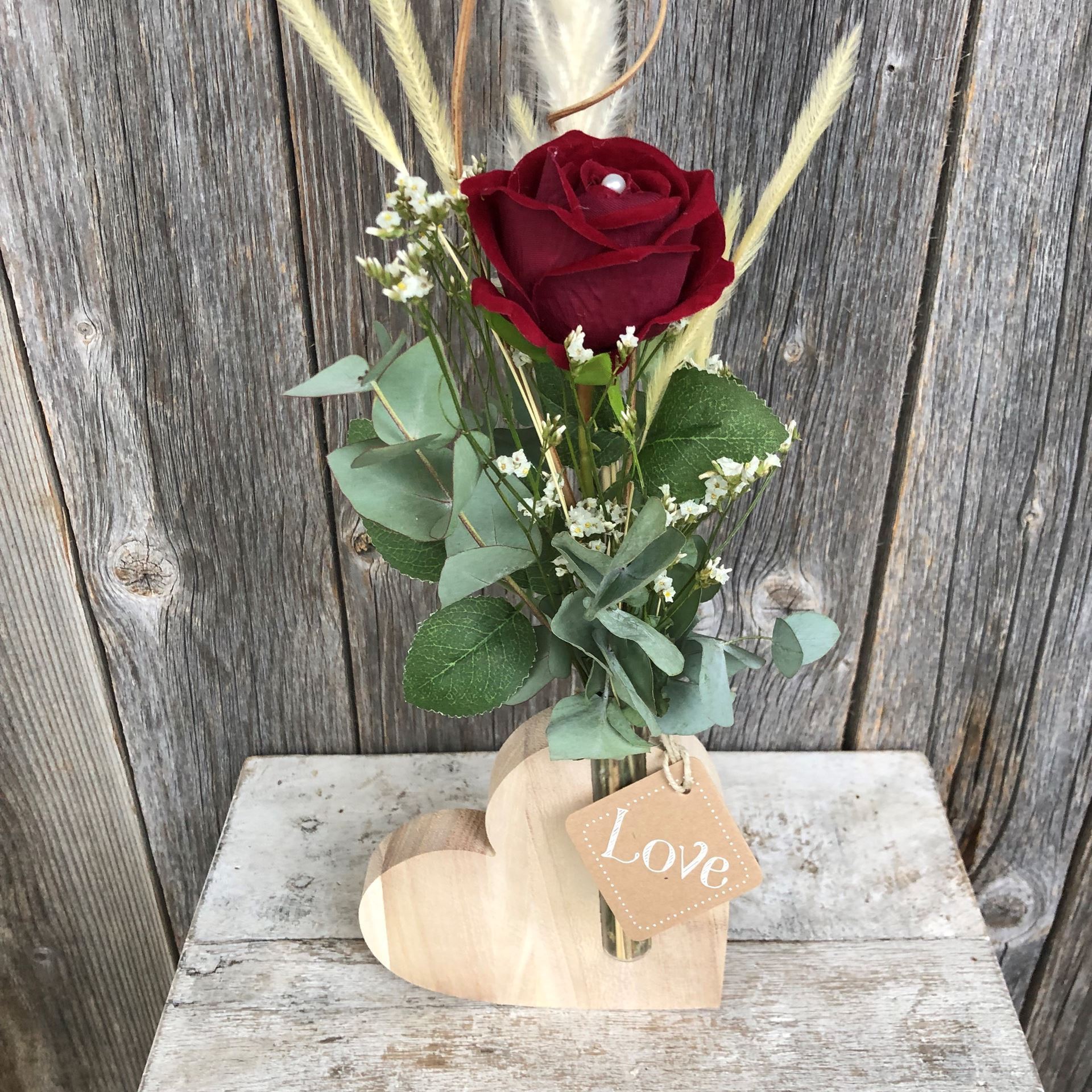 Herz aus Holz mit roter Rose geschmückt