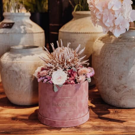 Samtbox in rosa, mit getrockneter Königs Protea, stabilisierten Rosen und Trockenblumen in rosa, pink und beige Ø 20 cm