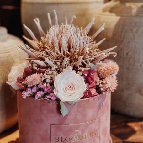 Samtbox in rosa, mit getrockneter Königs Protea, stabilisierten Rosen und Trockenblumen in rosa, pink und beige Ø 20 cm